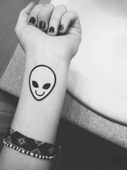 Smiling Alien Head Tattoo On Girl Left Wrist