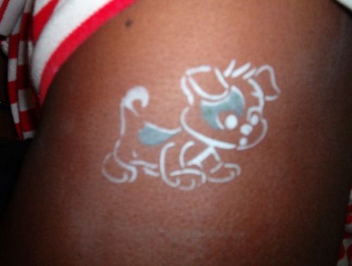 White ink puppy tattoo on siderib