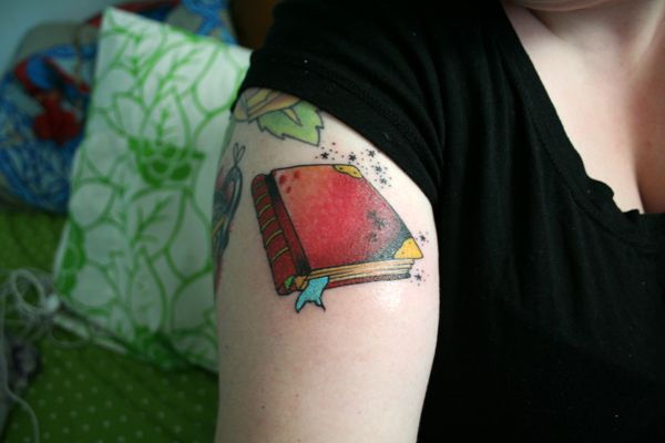 Amazing Red Book Tattoo On Girl Right Shoulder