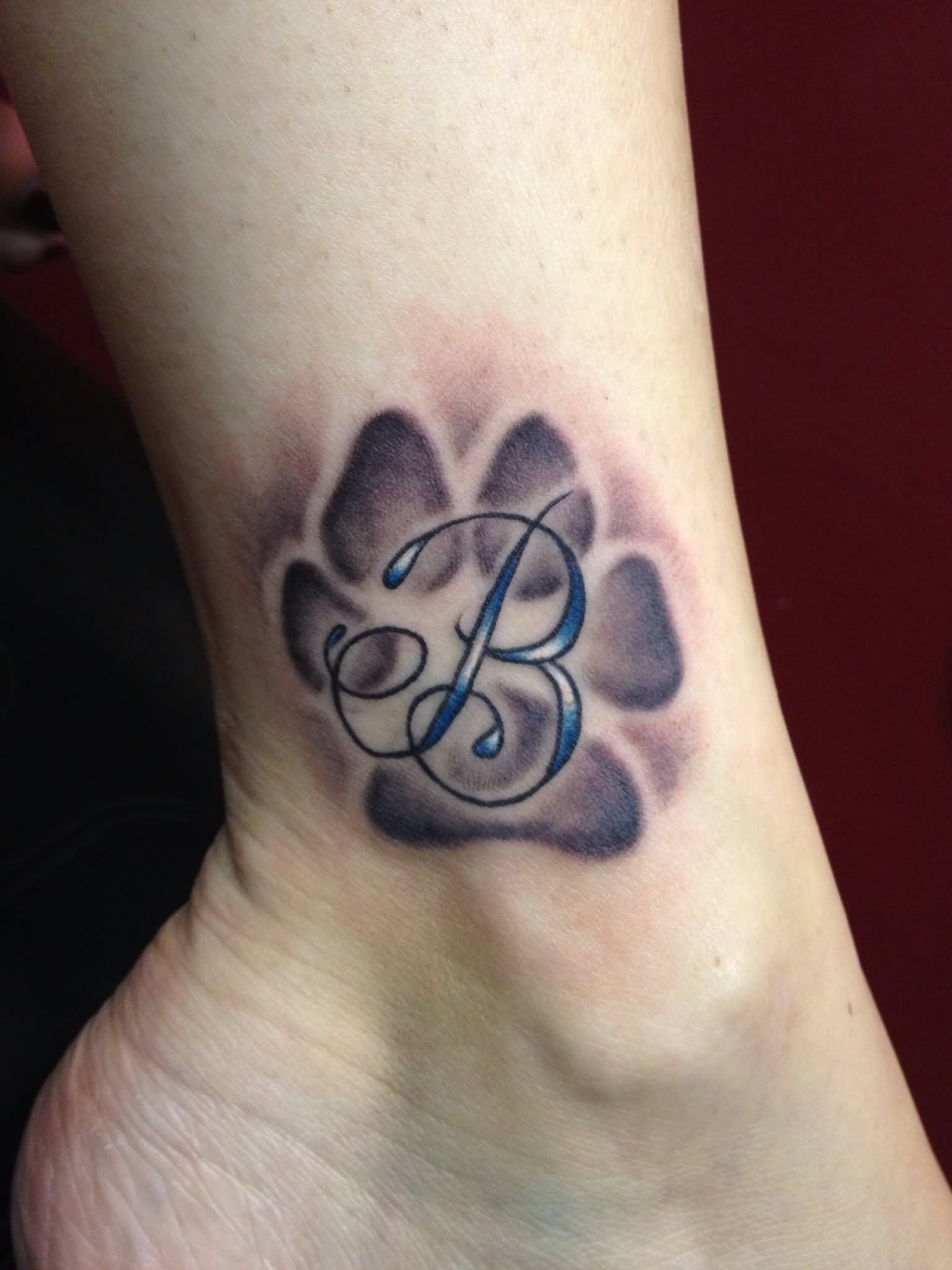 B Letter In Puppy Paw Tattoo On Leg