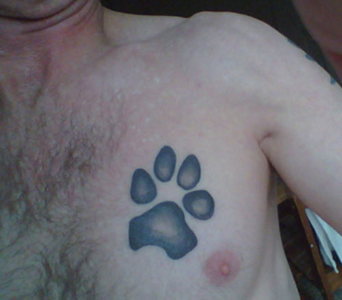 Black Ink Dog Puppy Paw Tattoo On Chest For Men