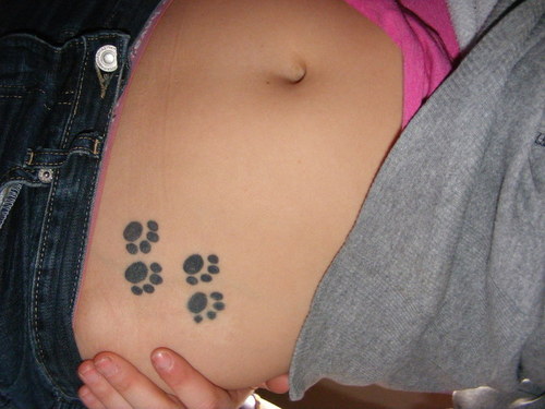 Girl Showing Her Puppy Paw Tattoos On Hip