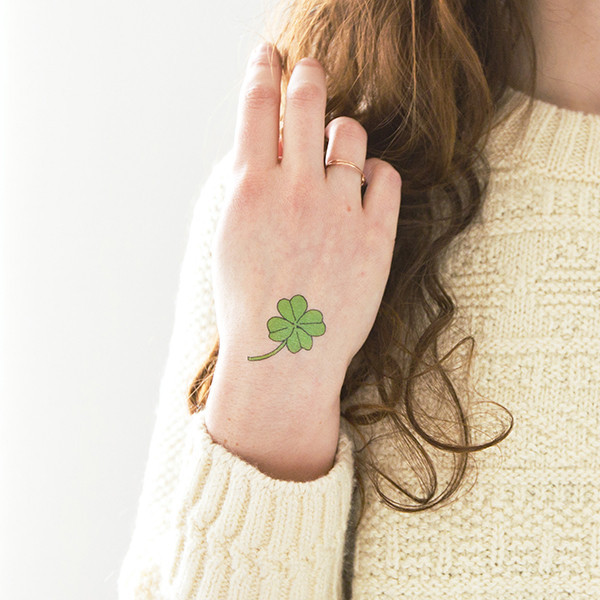 Green Ink Four Leaf Tattoo On Girl Hand