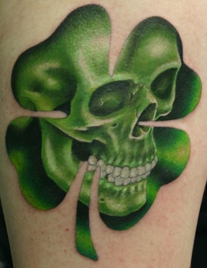 Green Ink Skull In Four Leaf Tattoo Design