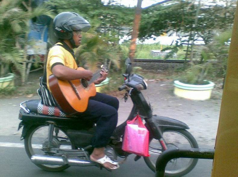 Man Playing Guitar On Running Bike Funny Asian Picture