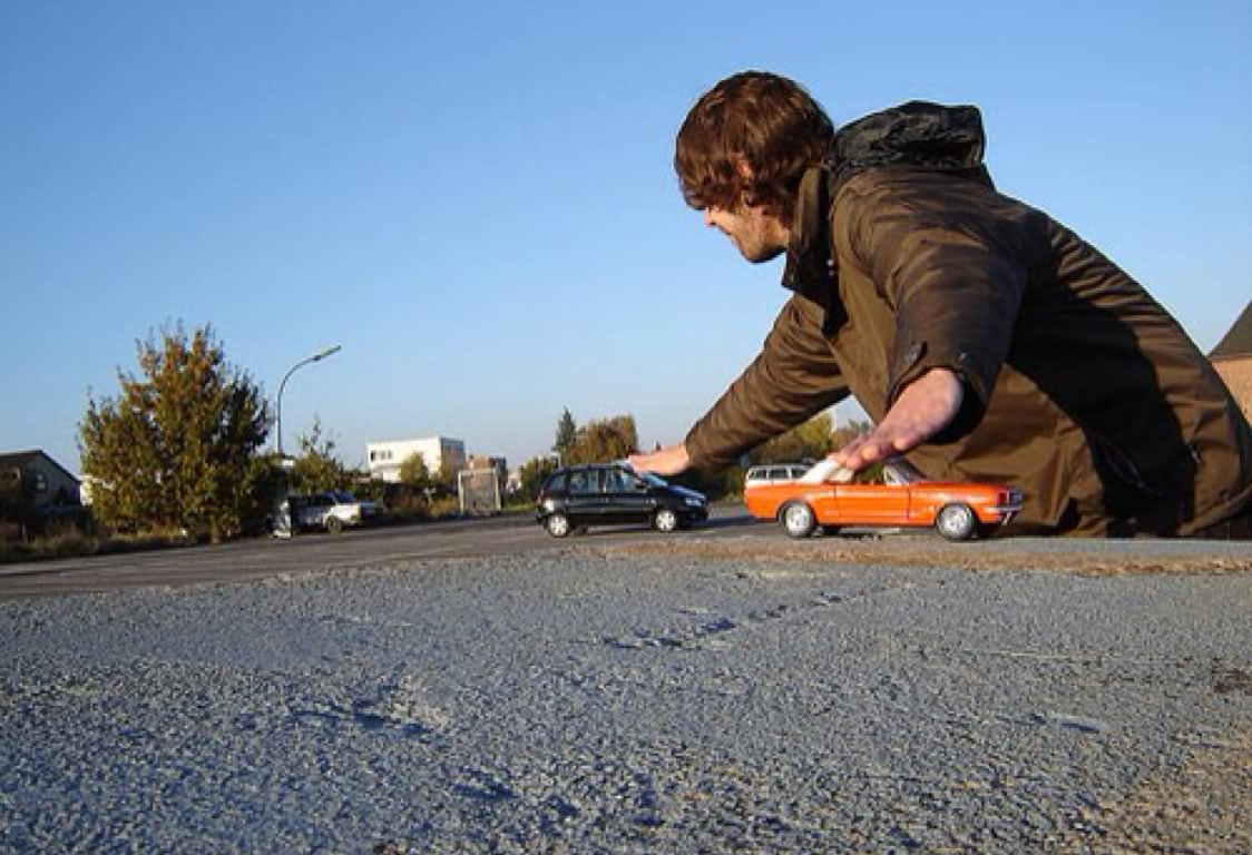 Man Playing With Cars Funny Unusual Angle Image