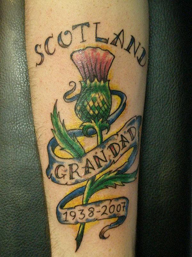 Memorial Thistle Flower With Banner Tattoo Design For Arm By Heaven N Hell
