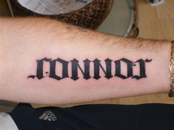 Black Ambigram Connor Lettering Tattoo On Forearm