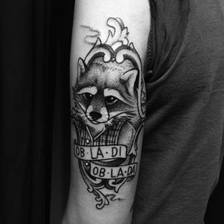 Black And Grey Raccoon In Frame With Banner Tattoo On Left Half Sleeve