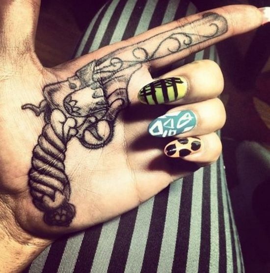Black Ink Gun Tattoo On Girl Hand Palm