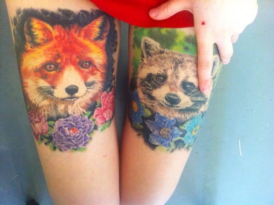 Colorful Two Raccoon Head With Flowers Tattoo On Both Thigh