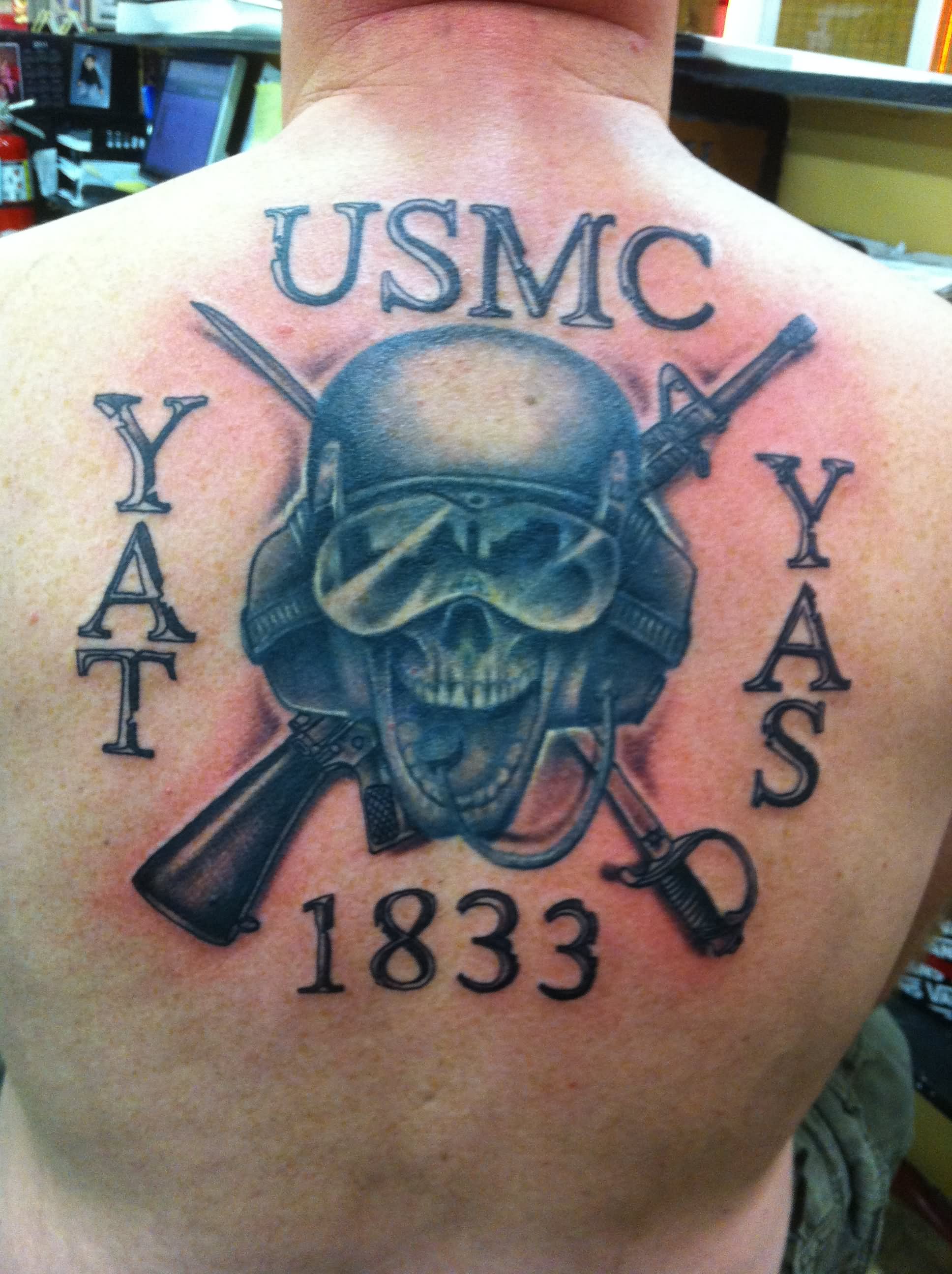 Memorial Marine Skull With Two Crossing Gun Tattoo On Man Upper Back