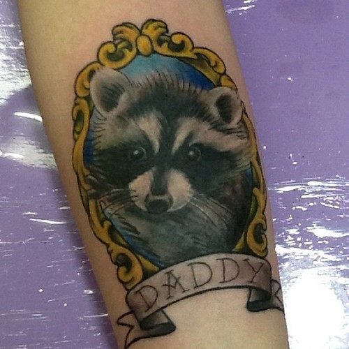 Raccoon Head In Frame With Banner Tattoo Design For Arm