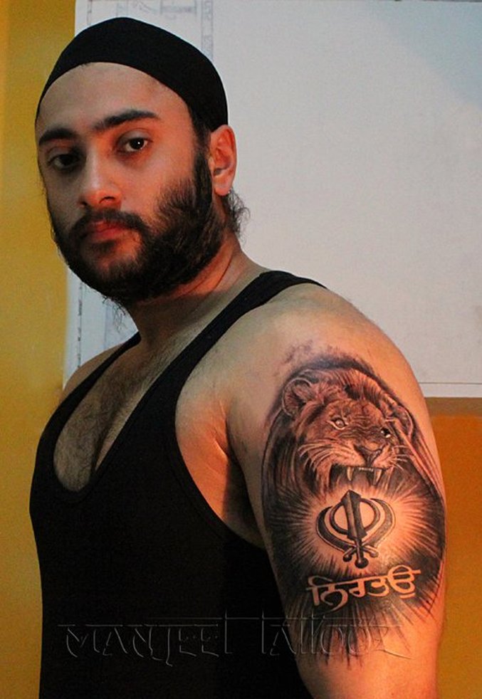 Amazing Sikhism Khanda With Lion Head Tattoo On Man Left Shoulder