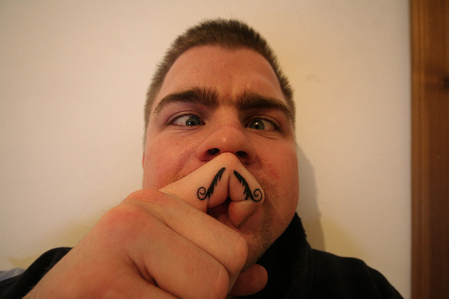 Awesome Black Mustache Tattoo On Man Finger
