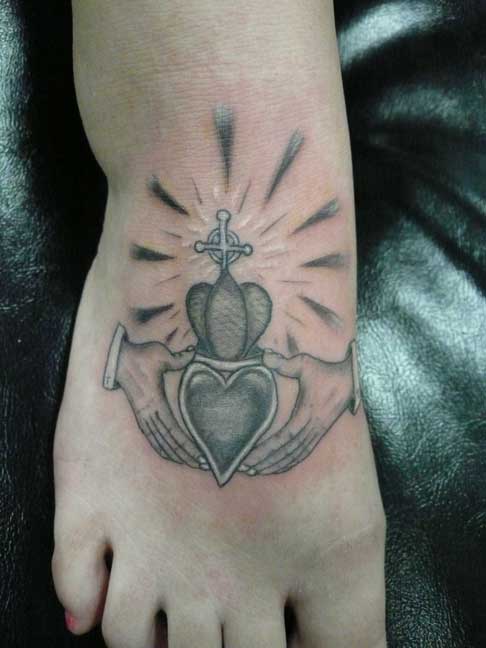 Black And Grey Claddagh Tattoo On Girl Foot