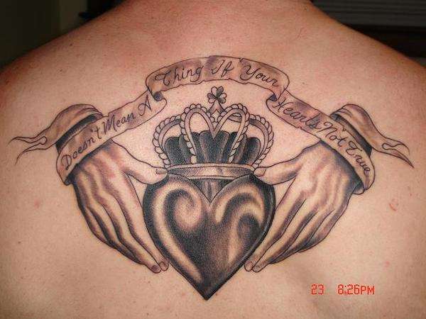 Black Ink Claddagh With Banner Tattoo On Upper Back