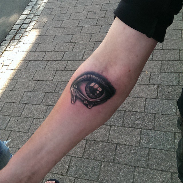 Black Ink Crying Eye Tattoo On Forearm