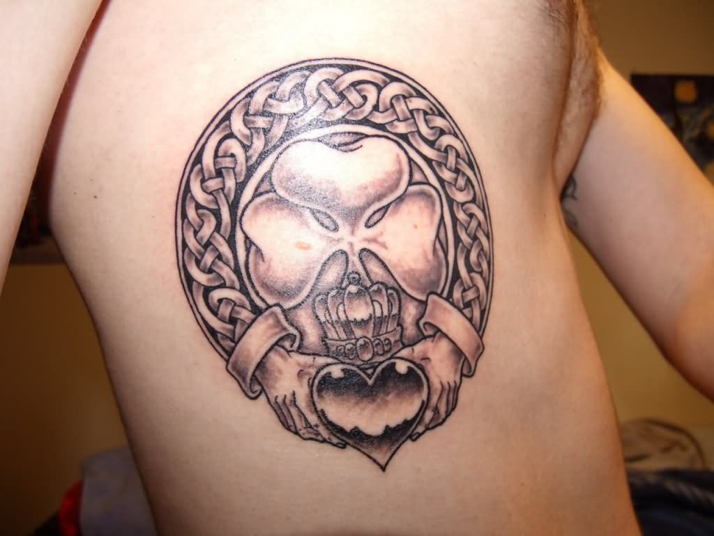 Black Ink Four Leaf In Claddagh Tattoo On Man Side Rib