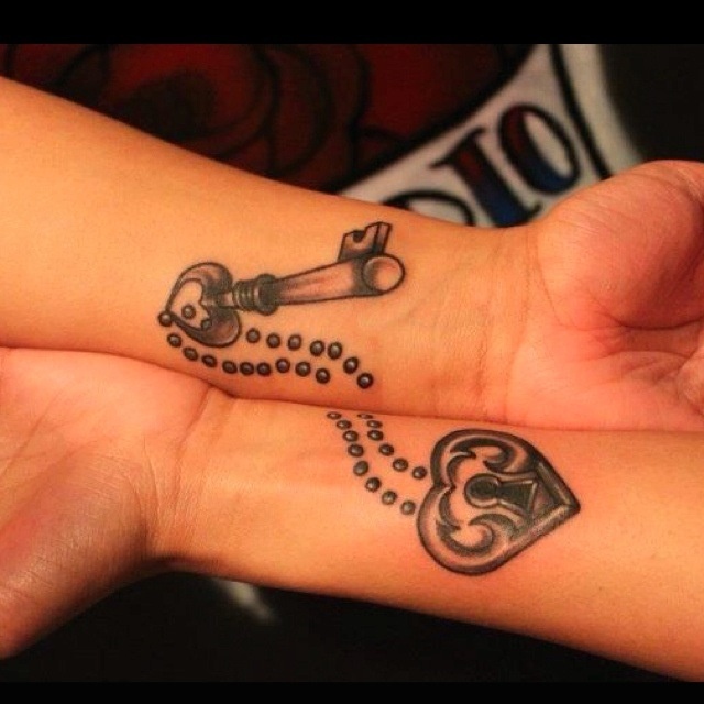 Black Ink Heart Shape Lock And Key Tattoo On Couple Wrist