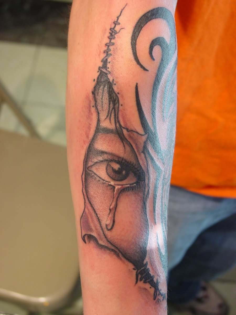 Black Ink Ripped Skin Crying Eye Tattoo On Forearm By Fabian Cobos