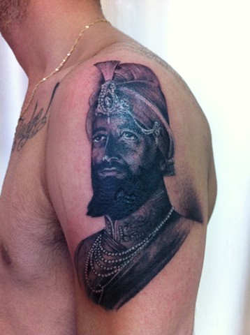 Black Ink Sikhism Guru Gobind Singh Ji Tattoo On Man Left Shoulder