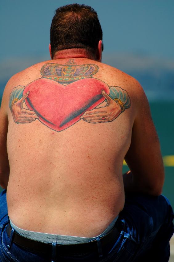 Colorful Claddagh Tattoo On Man Upper Back