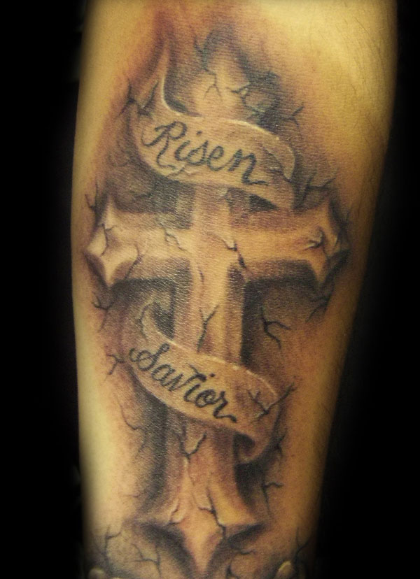 Freehand cracked stone cross tattoo with ribbon and some roses