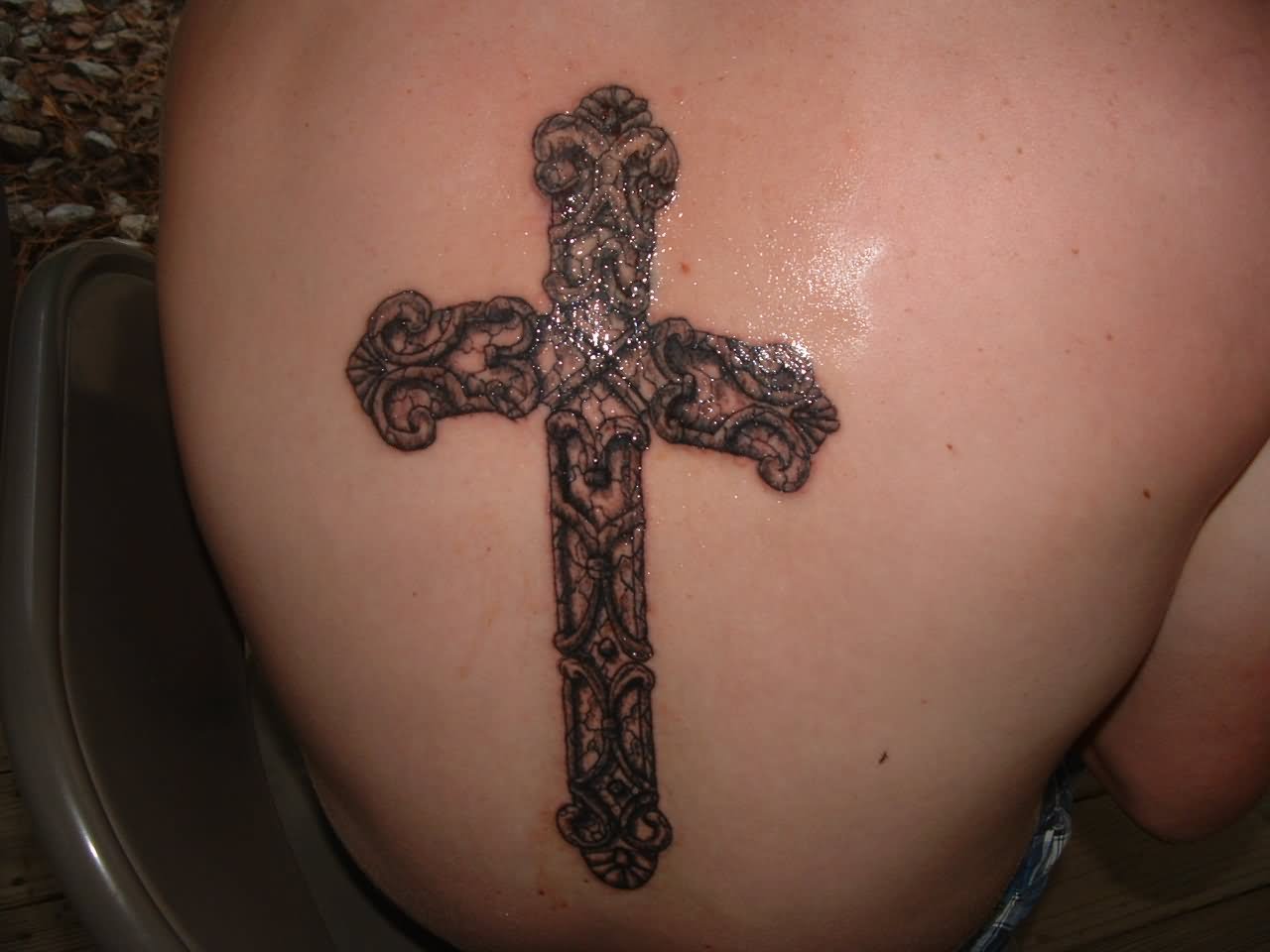 Freshly healed vintage cross tattoo on back