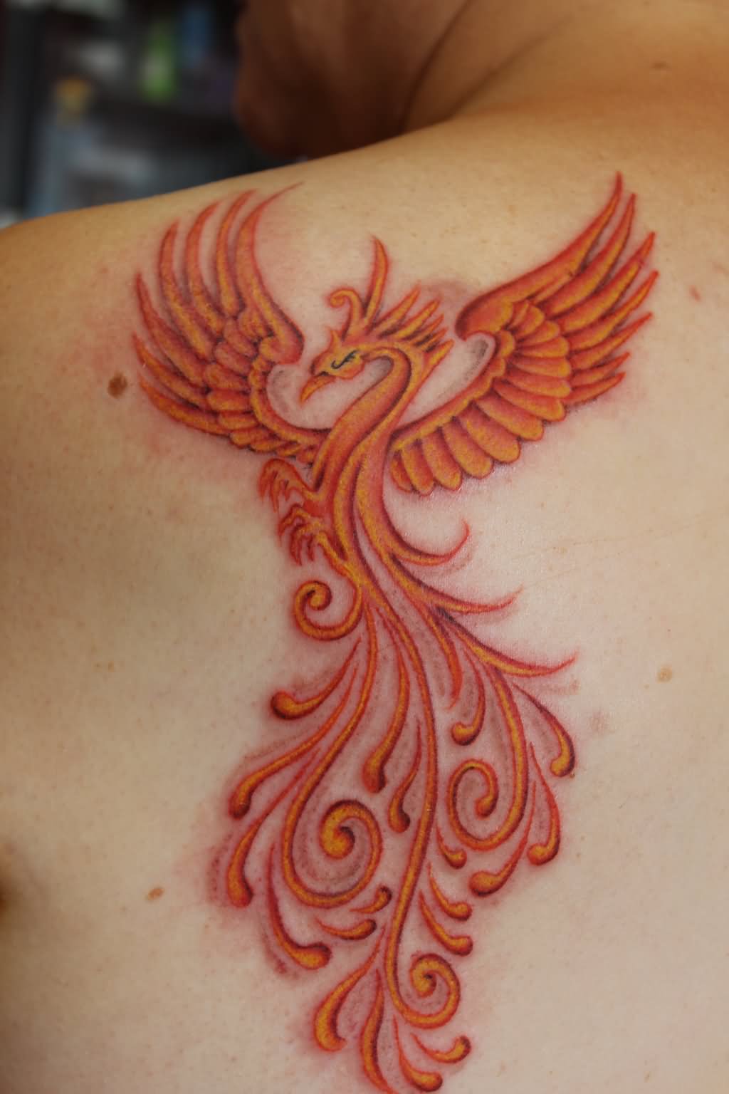 Orange Ink Phoenix Tattoo On Left Back Shoulder