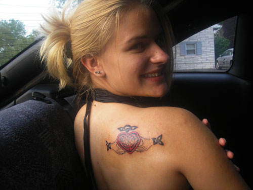 Red And Black Claddagh Tattoo On Girl Right Back Shoulder
