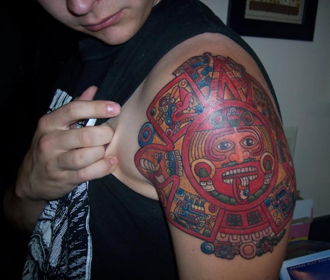 Red Ink Aztec Sun Tattoo On Left Shoulder
