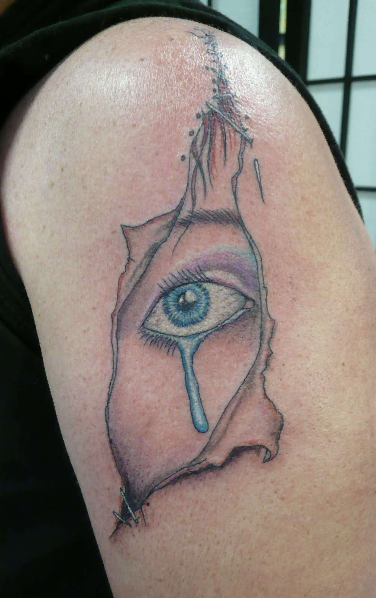 Ripped Skin Crying Eye Tattoo Design For Shoulder