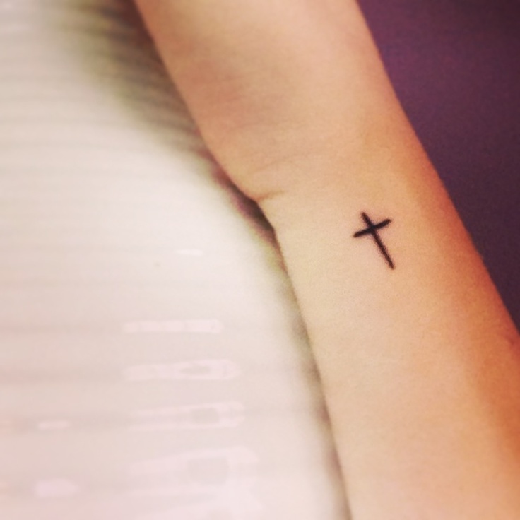 Tiny black cross tattoo