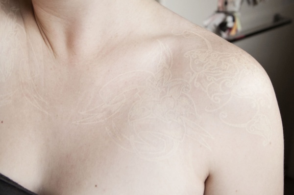 White Ink Flower Tattoo On Collarbone