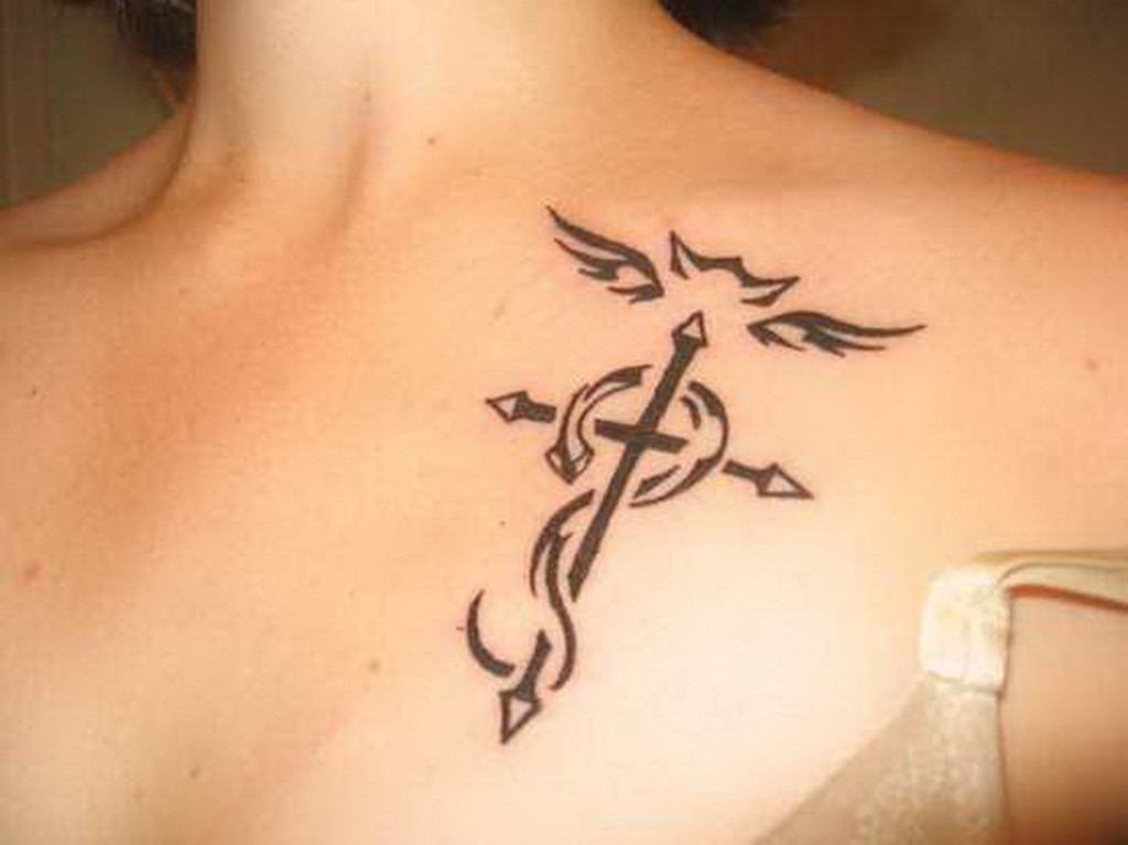 Winged tribal Cross tattoo on collar bone