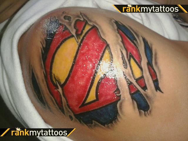 Colorful Ripped Skin Superman Logo Tattoo On Man Left Shoulder