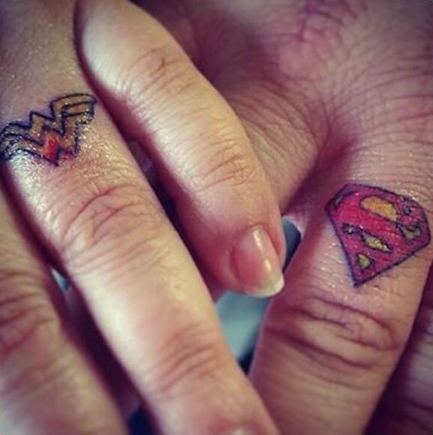 Colorful Wonder Women And Superman Logo Tattoo On Finger