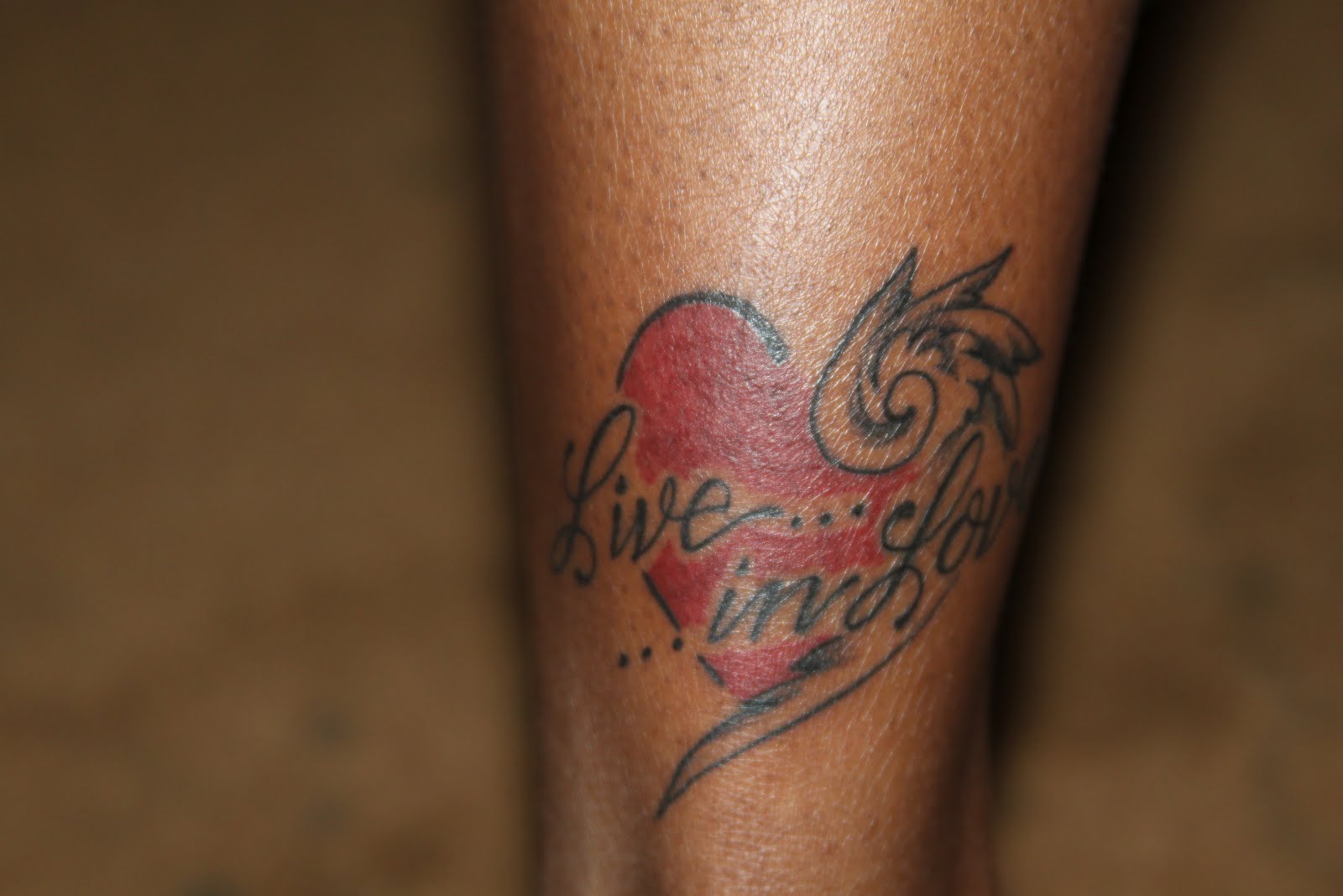 Red Heart With Live In Love Lettering Tattoo On Achilles