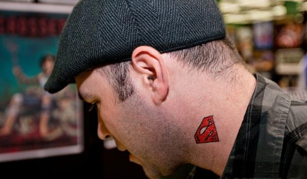 Red Superman Logo Tattoo On Man Side Neck