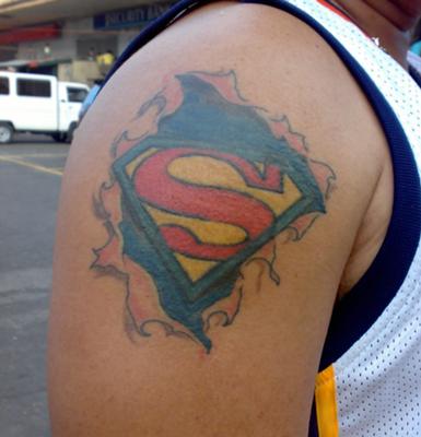 Ripped Skin Superman Logo Tattoo On Man Right Shoulder