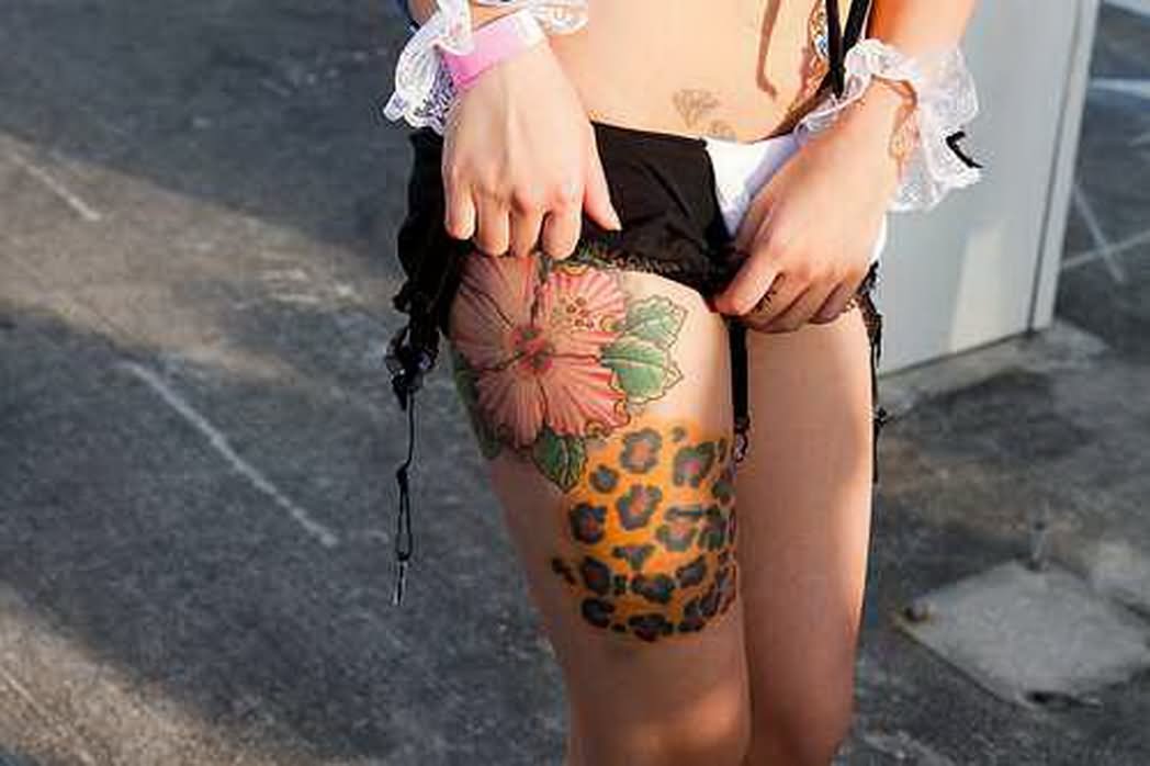 Beautiful Flowers And Cheetah Print Tattoo On Thigh