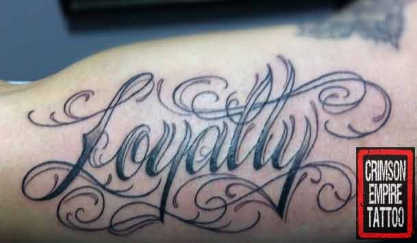 Black And Grey Loyalty Tattoo On Muscles