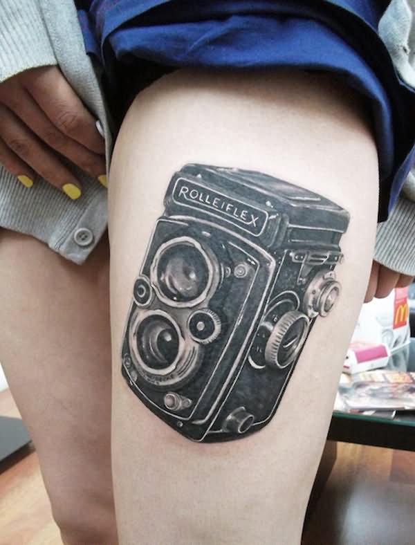 Black And Grey Movie Camera Tattoo On Thigh