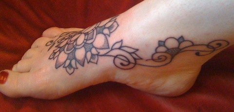 Black Ink Flower Tattoo On Girl Foot