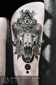 Black Ink Illuminati Eye In Goat Skull With Roses Tattoo On Thigh