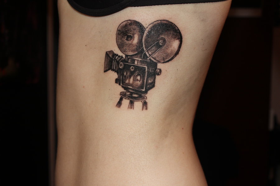 Black Ink Movie Camera Tattoo On Side Rib