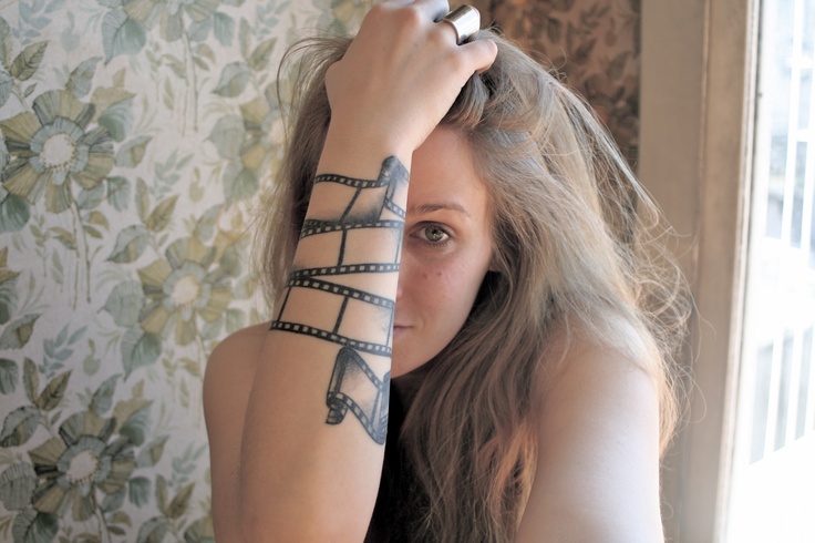 Black Movie Camera Reel Tattoo On Girl Right Forearm