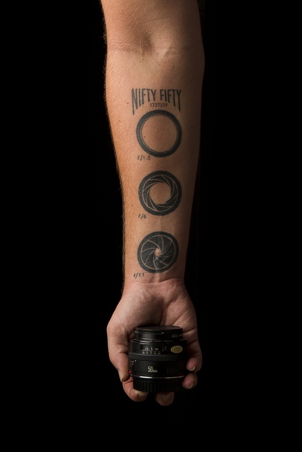 Black Three Movie Camera Lens Tattoo On Forearm