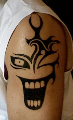 Black Tribal laughing Clown Head Tattoo On Shoulder